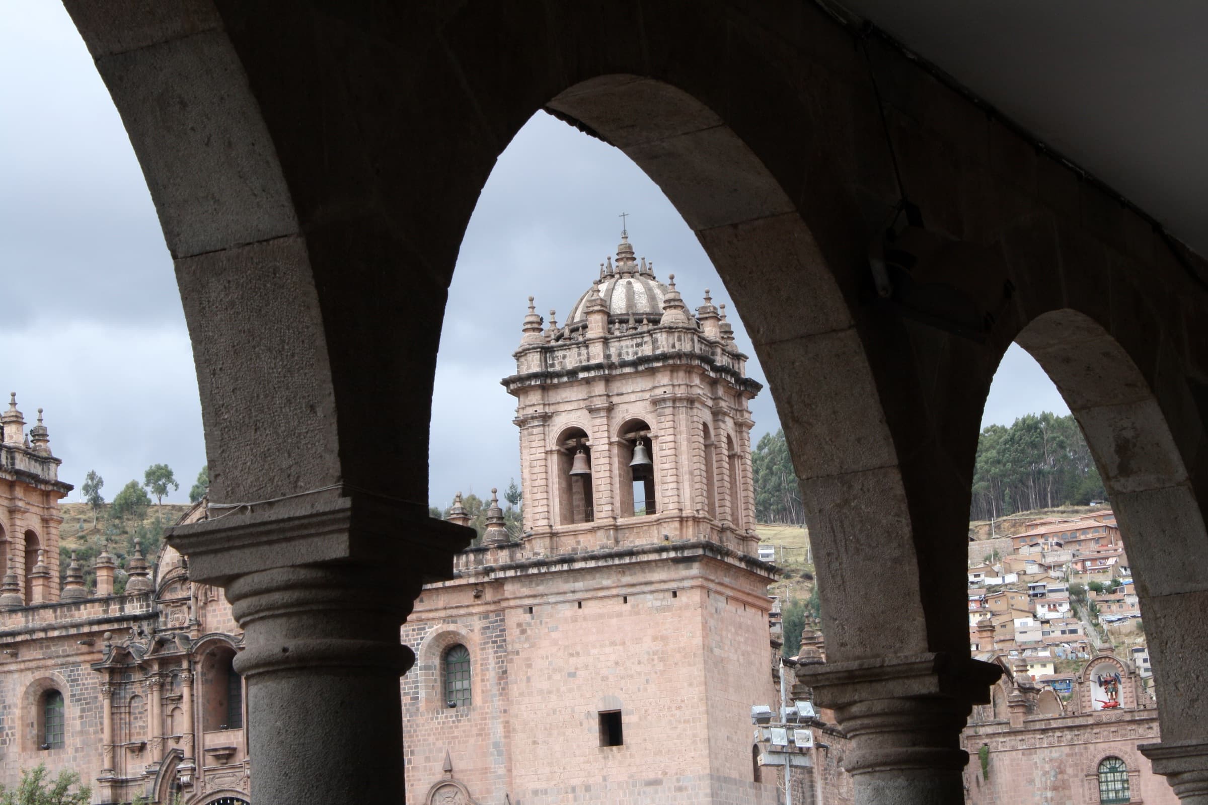 Colonial arches framing a cathedral in Cusco, Peru