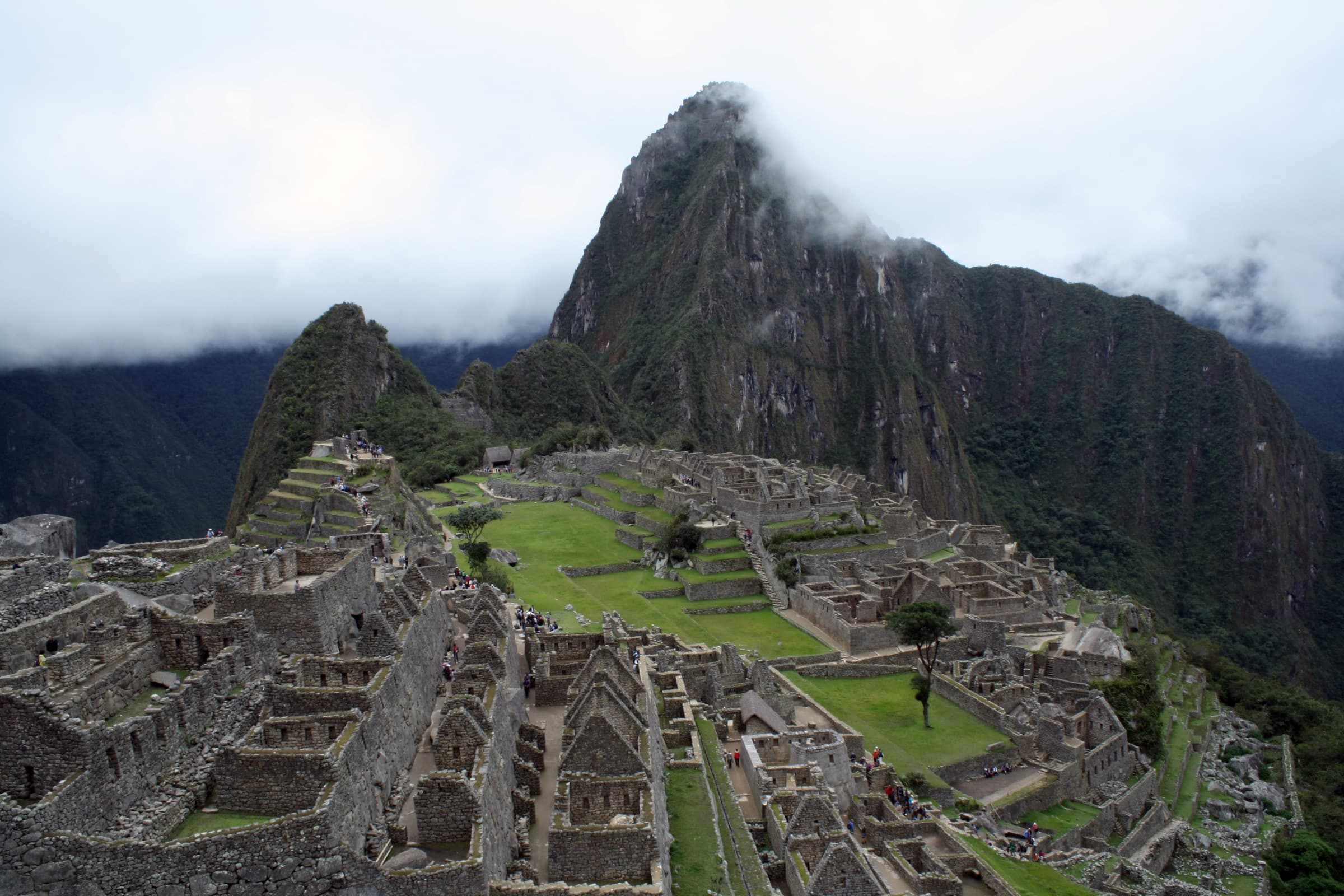 Machu Picchu ruins beneath a cloud-wrapped peak